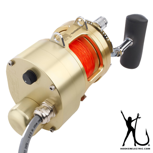 Gold Tiagra Reel with motor on side and grey power cable protruding. Spooled with neon orange line.